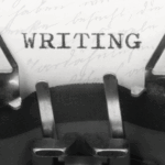 A typewriter has typed the word WRITING on a white piece of paper